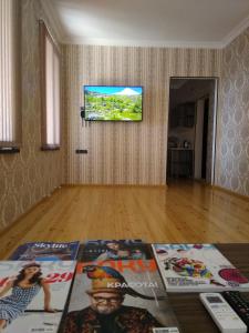 a living room with a flat screen tv on a wall at VM Hostel in Ganja