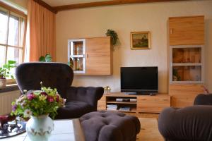 a living room with two chairs and a flat screen tv at Haus Martina in Siegsdorf