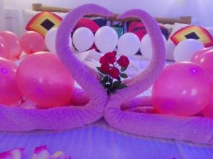 a table with two pink baskets with flowers and balloons at New Green View Resort in Ella