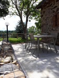 einen Tisch und Stühle auf einer Terrasse in der Unterkunft Gite de Villodier in Le Vigeant