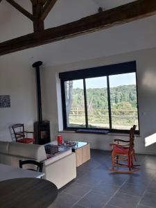 ein Wohnzimmer mit einem Sofa und einem großen Fenster in der Unterkunft Gite de Villodier in Le Vigeant