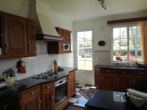 a kitchen with wooden cabinets and black counter tops at Quinta do sossego in Pico da Pedra