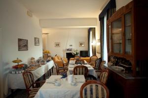 a dining room with tables and chairs with white tablecloths at Villa Margherita in Levanto