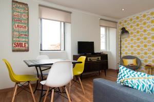 uma sala de estar com uma mesa e cadeiras amarelas em Casa da Espera em Lisboa