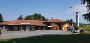 a building with a sign on the side of it at Hôtel Eco Logis Espace Bellevue in Séméac