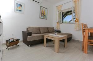 ein Wohnzimmer mit einem Sofa und einem Tisch in der Unterkunft Holiday Home Lučica in Sutivan