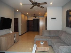 sala de estar con sofá y TV de pantalla plana en Beautiful 3 Bedroom Garden Villa, en Chalong 