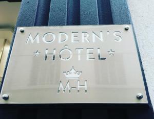 un panneau indiquant un hôtel situé sur le côté d'un bâtiment dans l'établissement Modern's Hotel, à Paris