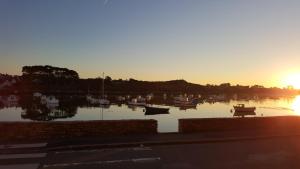 a group of boats sitting in the water at sunset at CHAMBRES D'HOTES PORTSALL in Ploudalmézeau