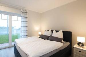 a bedroom with a large bed and a large window at Fewo Obsthof Matthies in Jork