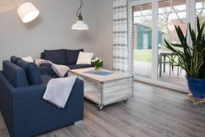 Sala de estar con sofá azul y mesa de centro en Fewo Obsthof Matthies, en Jork