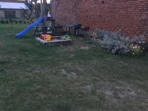 a yard with a playground with a slide and a play set at Nocleg na Mazurach in Stacze
