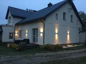 a white house with lights on the side of it at Nocleg na Mazurach in Stacze