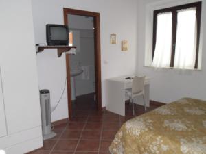 a bedroom with a bed and a desk with a television at Poggio Petrella in Manciano