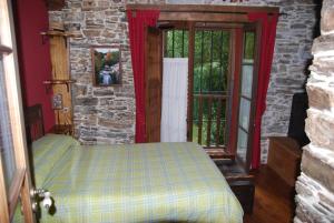 1 dormitorio con cama y pared de piedra en Pereje Garden, en Pereje