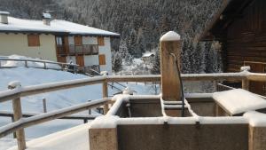 una recinzione ricoperta di neve accanto a una casa di Il Cardo Trentino a Bedollo