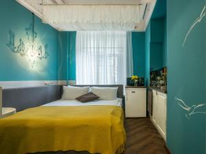 ein Schlafzimmer mit einem Bett mit einer gelben Decke in der Unterkunft Apart Hotel Michelle in Odessa