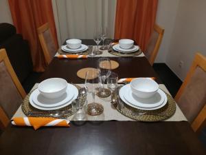 uma mesa com pratos e copos por cima em Apartamento BaySide - São Martinho do Porto em São Martinho do Porto