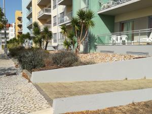 a sidewalk in front of a building with palm trees at Apartamento BaySide - São Martinho do Porto in São Martinho do Porto