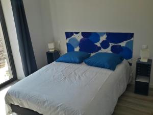 ein Schlafzimmer mit einem großen Bett mit blauen Kissen in der Unterkunft Gite de Villodier in Le Vigeant