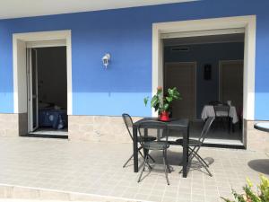 a table and chairs on a patio with a blue wall at B&B Honey Rooms in Saronno +12 photos