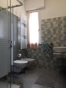 a bathroom with a toilet and a sink and a tub at B&B Honey Rooms in Saronno