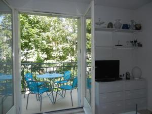 a room with a balcony with a table and chairs at Les Jardins du Casino T2 bis- 4 personnes-Tarif cures in Luchon