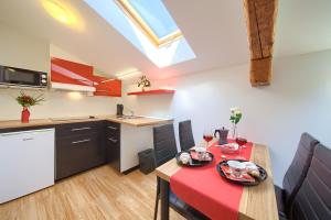 a kitchen and dining room with a red table and chairs at Apartments Muciceva Ravan in Jurdani