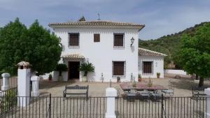 a white house with a fence in front of it at Casa de la Higuera in Priego de Córdoba