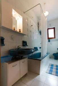 y baño con lavabo y bañera azul. en Casa vacanze " L' ORCHIDEA " Sapri, en Sapri