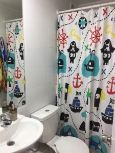 a bathroom with a toilet and a shower curtain at Departamento La Serena 6 Personas in La Serena