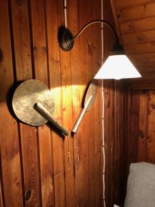 dwa metalowe haki na drewnianej ścianie ze światłem w obiekcie Tleniowo w Tleniu