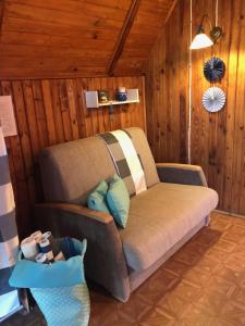 un divano in camera con pareti in legno di Tleniowo a Tleń