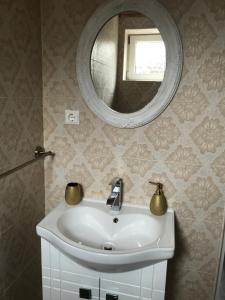 ein Bad mit einem Waschbecken und einem Spiegel in der Unterkunft Home Simoni in Ploieşti