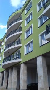 un edificio verde con balcones en un lateral en Apartament Ramona en Braşov