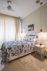 um quarto com uma cama com uma colcha azul e branca em Copacabana, conforto e localização no Rio de Janeiro