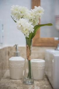 un vase rempli de fleurs blanches à côté d'une bougie dans l'établissement Copacabana, conforto e localização, à Rio de Janeiro