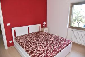 a bedroom with a bed with a red wall at Casa Annadelia in Silvi Paese