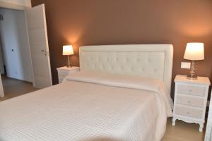 a bedroom with a white bed with two night stands at Casa Annadelia in Silvi Paese
