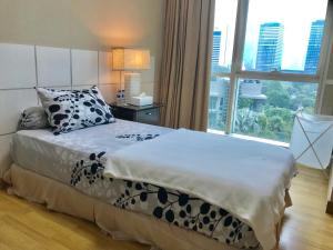 um quarto com uma cama e uma grande janela em The Peak Residence at Sudirman - 3 BR Exclusive Private Apartment em Jakarta