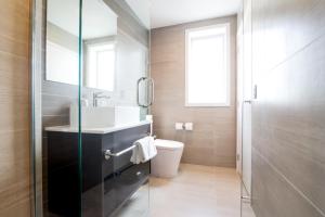 a bathroom with a sink and a toilet at The Sebel Auckland Manukau in Auckland