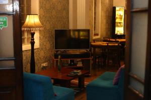 sala de estar con TV, sofá y mesa en Villa 92 City Stay en Kandy