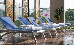 ホーチミン・シティにあるOrchids Saigon Hotelのデッキの青と白のラウンジチェア