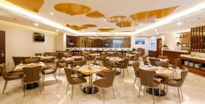 ホーチミン・シティにあるOrchids Saigon Hotelのテーブルと椅子とバーのあるレストラン
