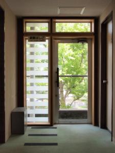 een ingang naar een kamer met deuren en ramen bij Tsukuba Daily Inn in Tsukuba