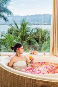 a woman sitting in a bath tub filled with flowers at Swiss-Belhotel Silae Palu in Palu