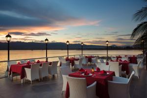 a restaurant with red and white tables and chairs at Swiss-Belhotel Silae Palu in Palu