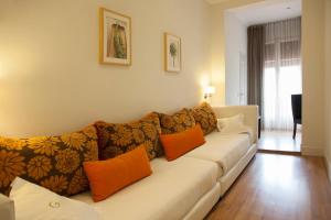 a living room with a white couch with orange pillows at Hostal Goya in Barcelona