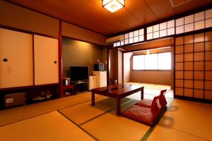una habitación con una mesa y un sofá. en Kafutei, en Yamaga