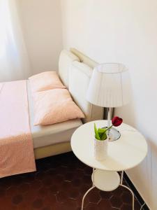 een witte tafel met een lamp en een bed bij The Gate to Cinque terre in La Spezia